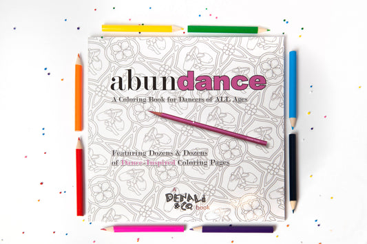 Coloring book titled 'abundance' with colored pencils on a white background