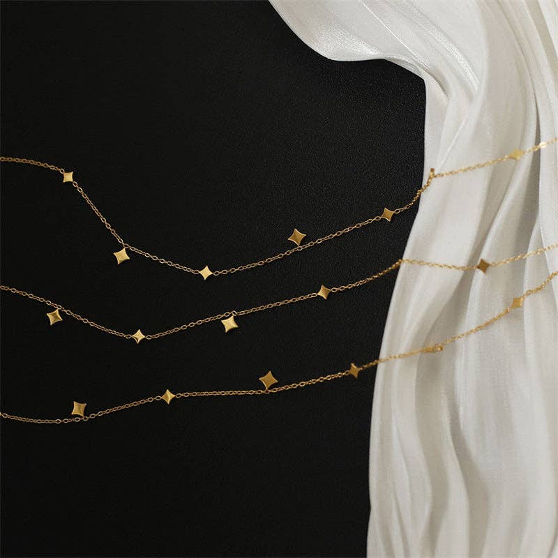 Gold chain necklace on a black mannequin with a white fabric background