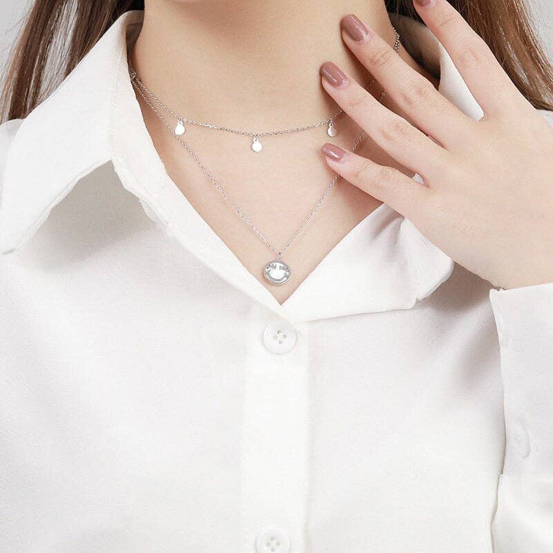 Necklace with a pendant worn by a person in a white shirt