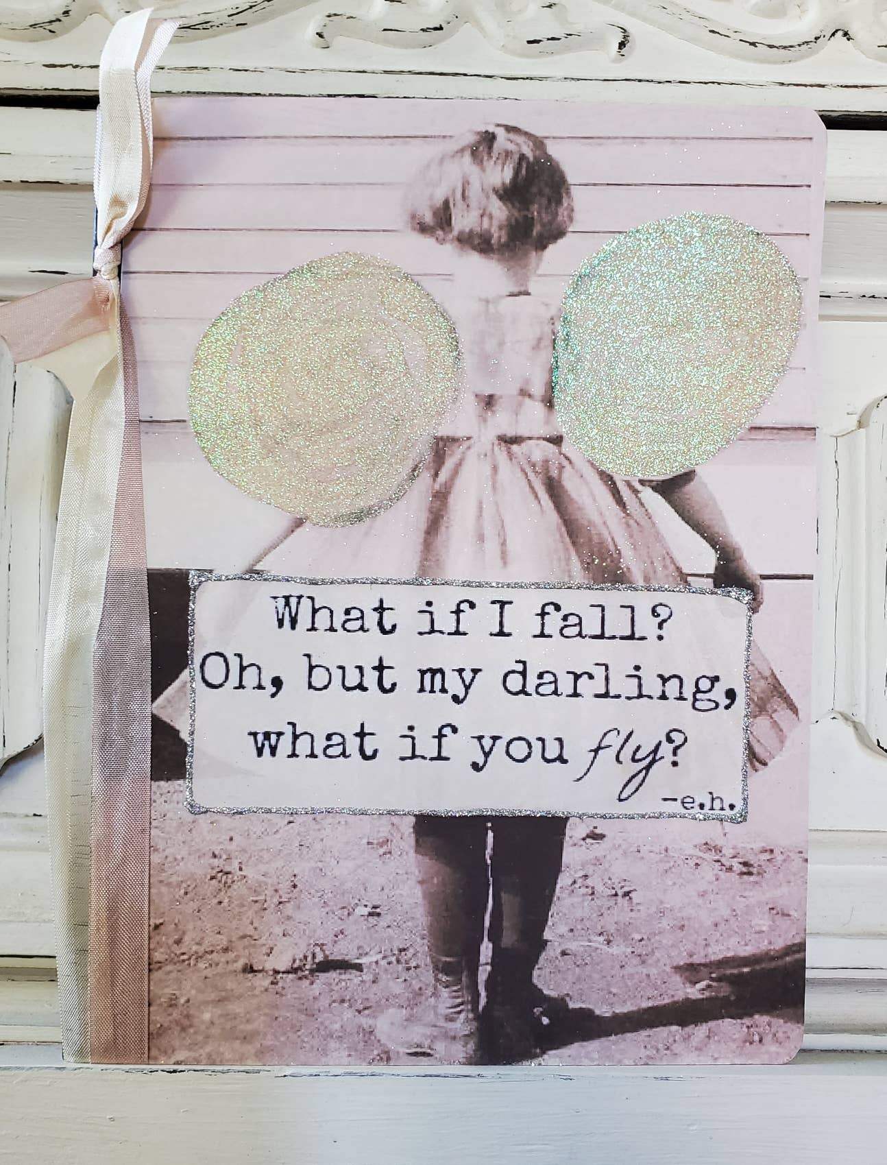 Decorative sign with a child with wings and a quote on a wooden background