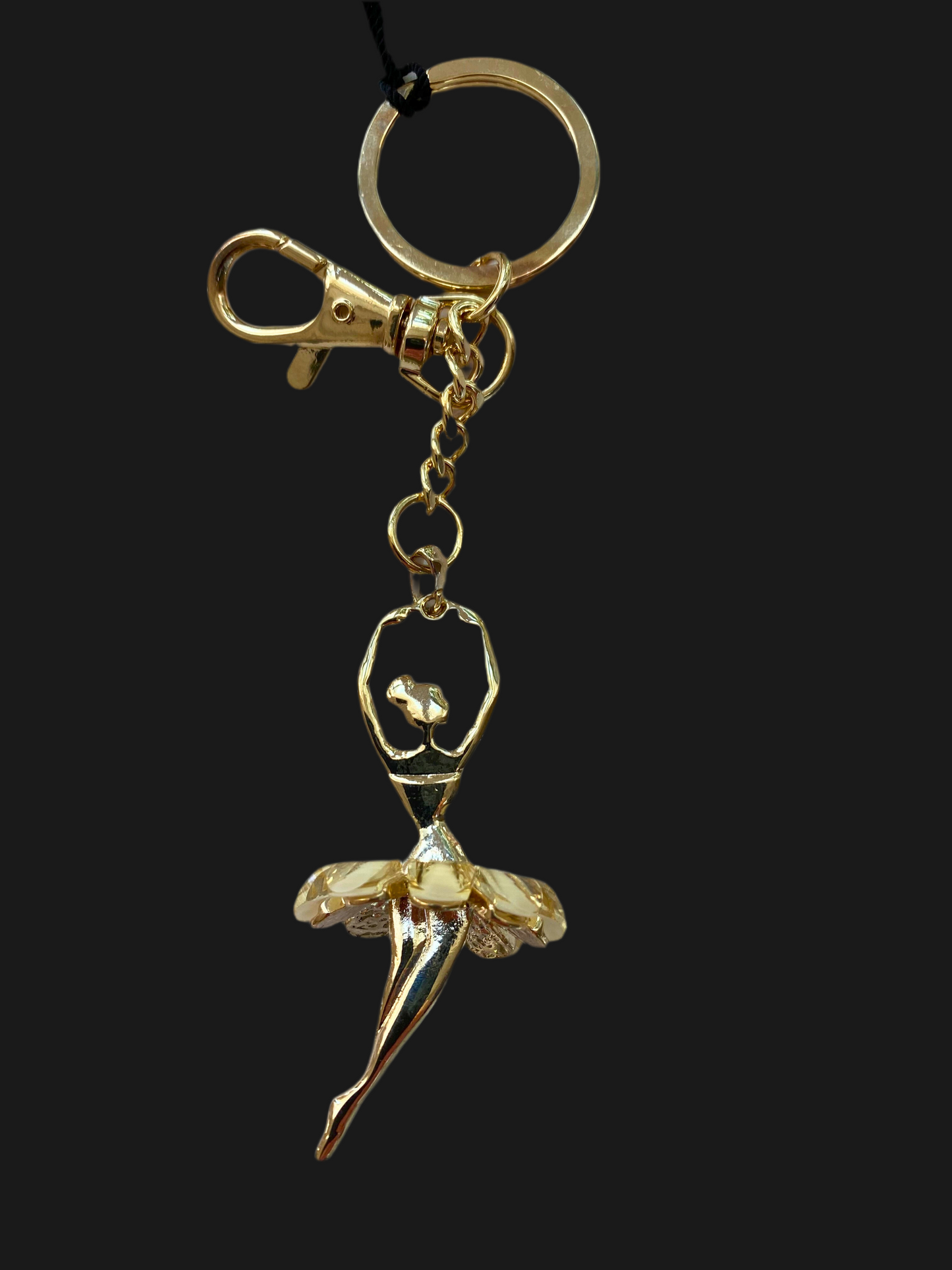 Gold keychain with a ballerina design on a black background