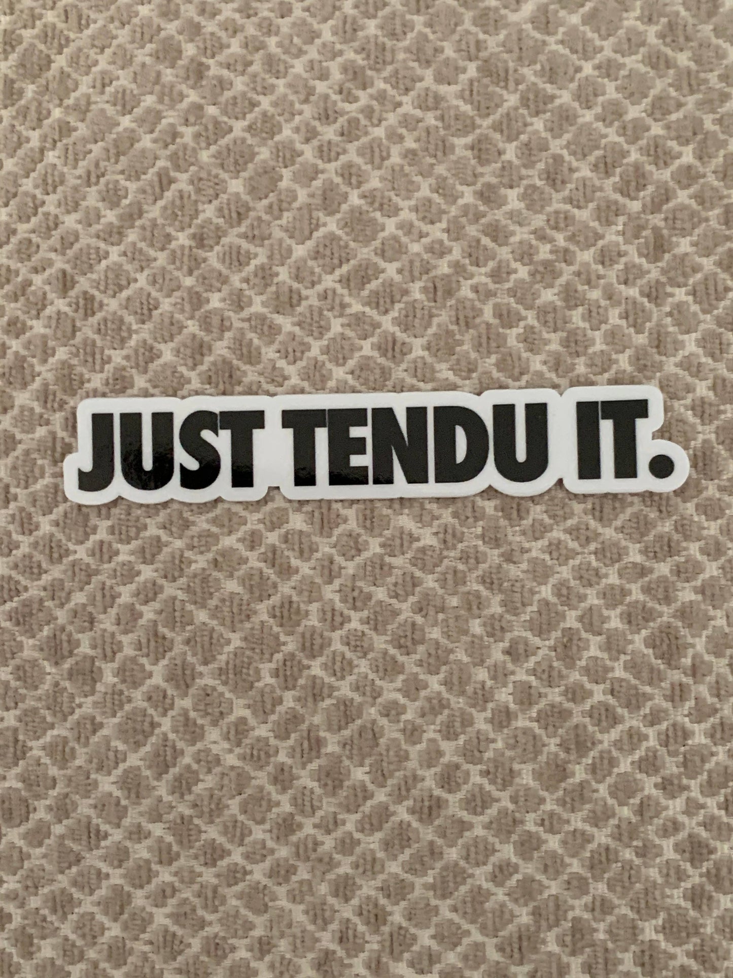Sticker with 'JUST TENDU IT.' text on a textured beige background
