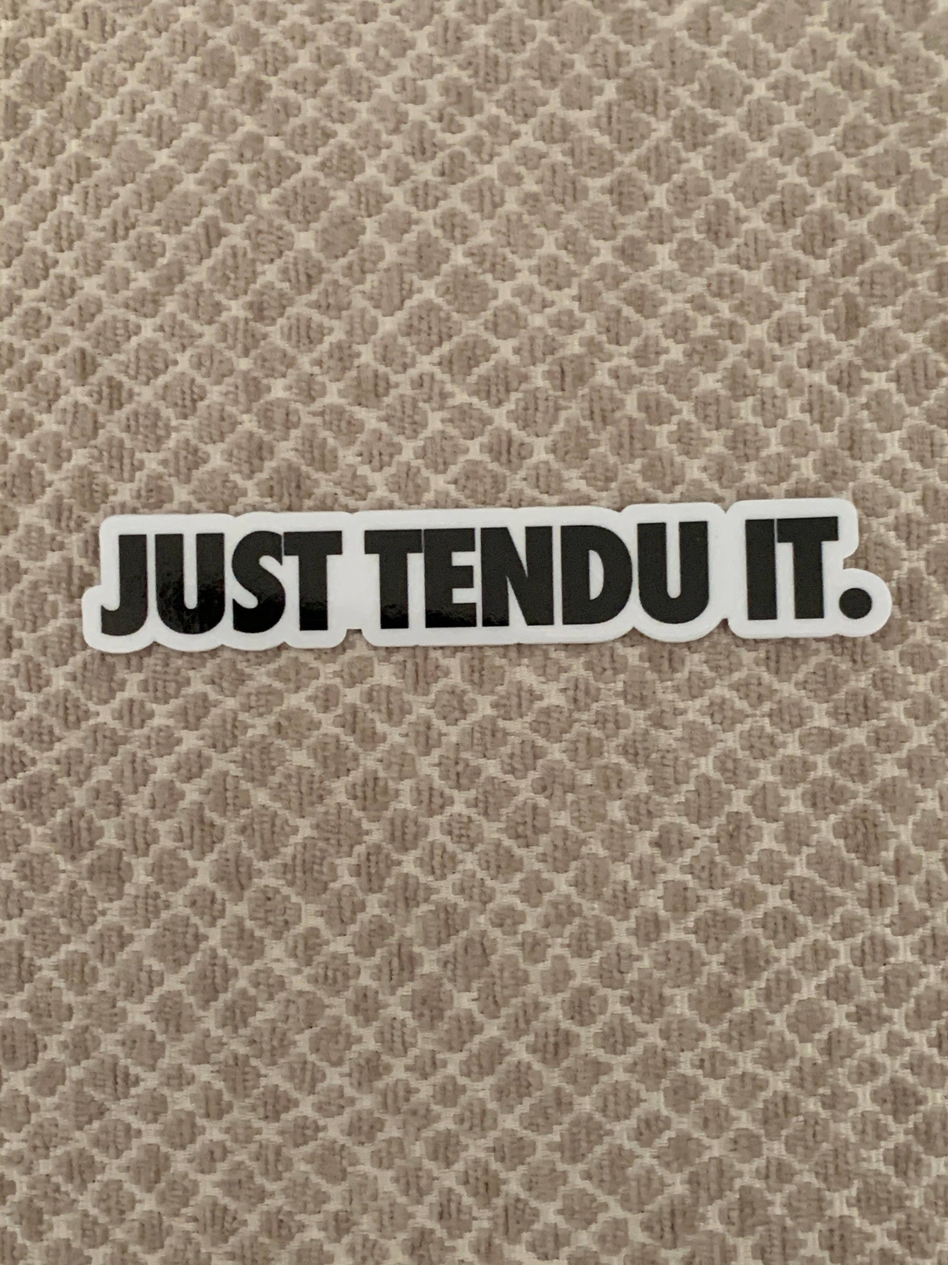 Sticker with 'JUST TENDU IT.' text on a textured beige background