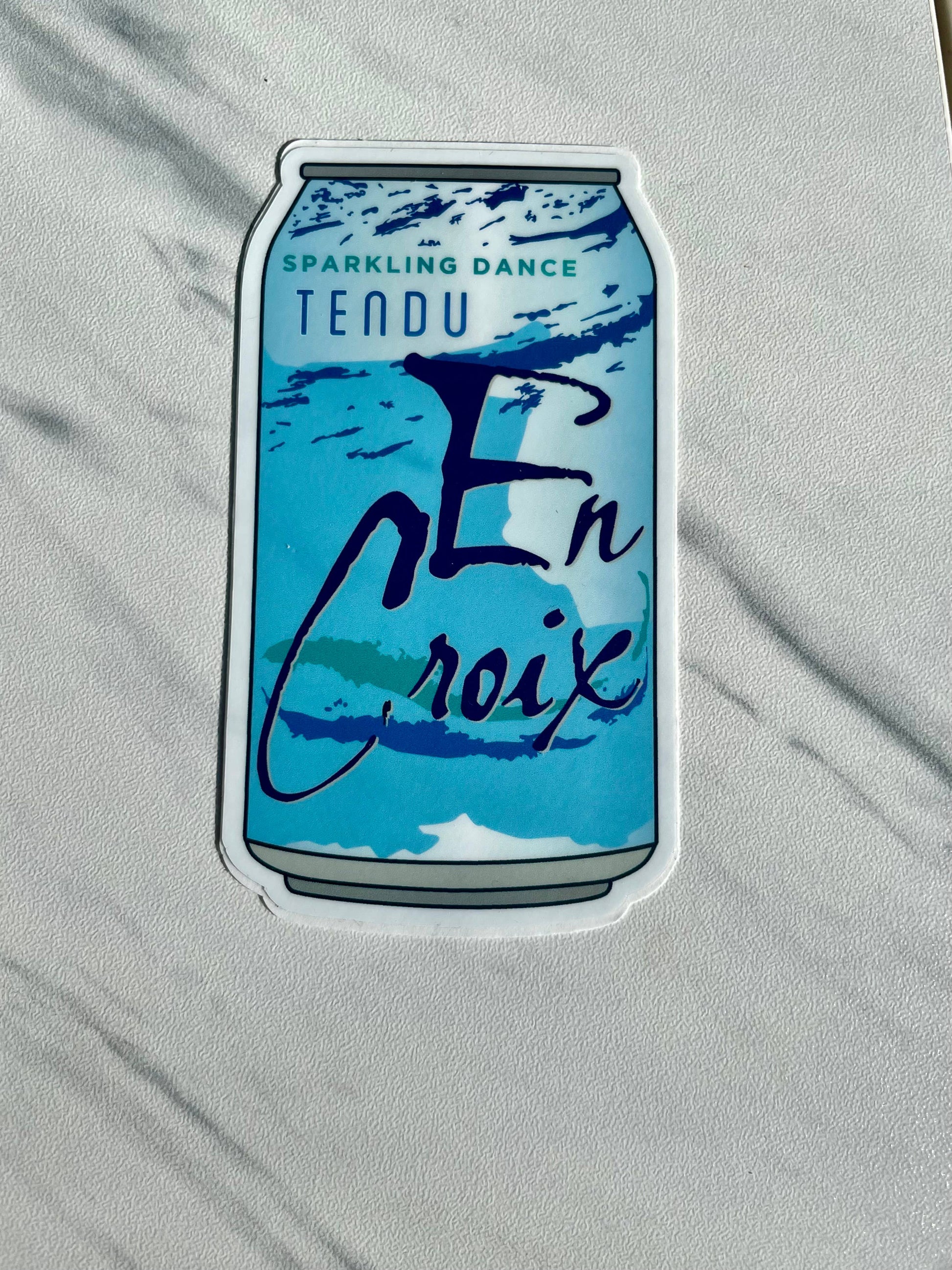 Sticker of a blue can with text on a gray background