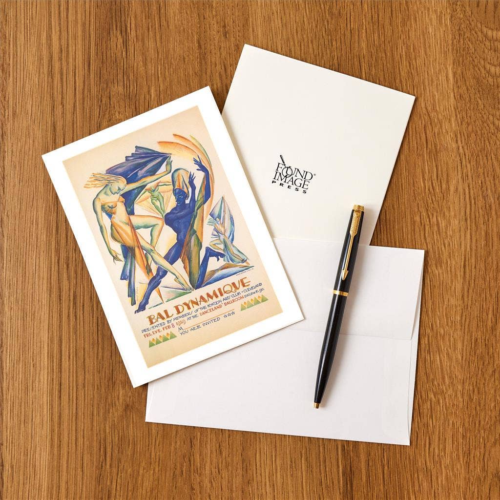 Greeting card with abstract design, envelope, and pen on a wooden surface