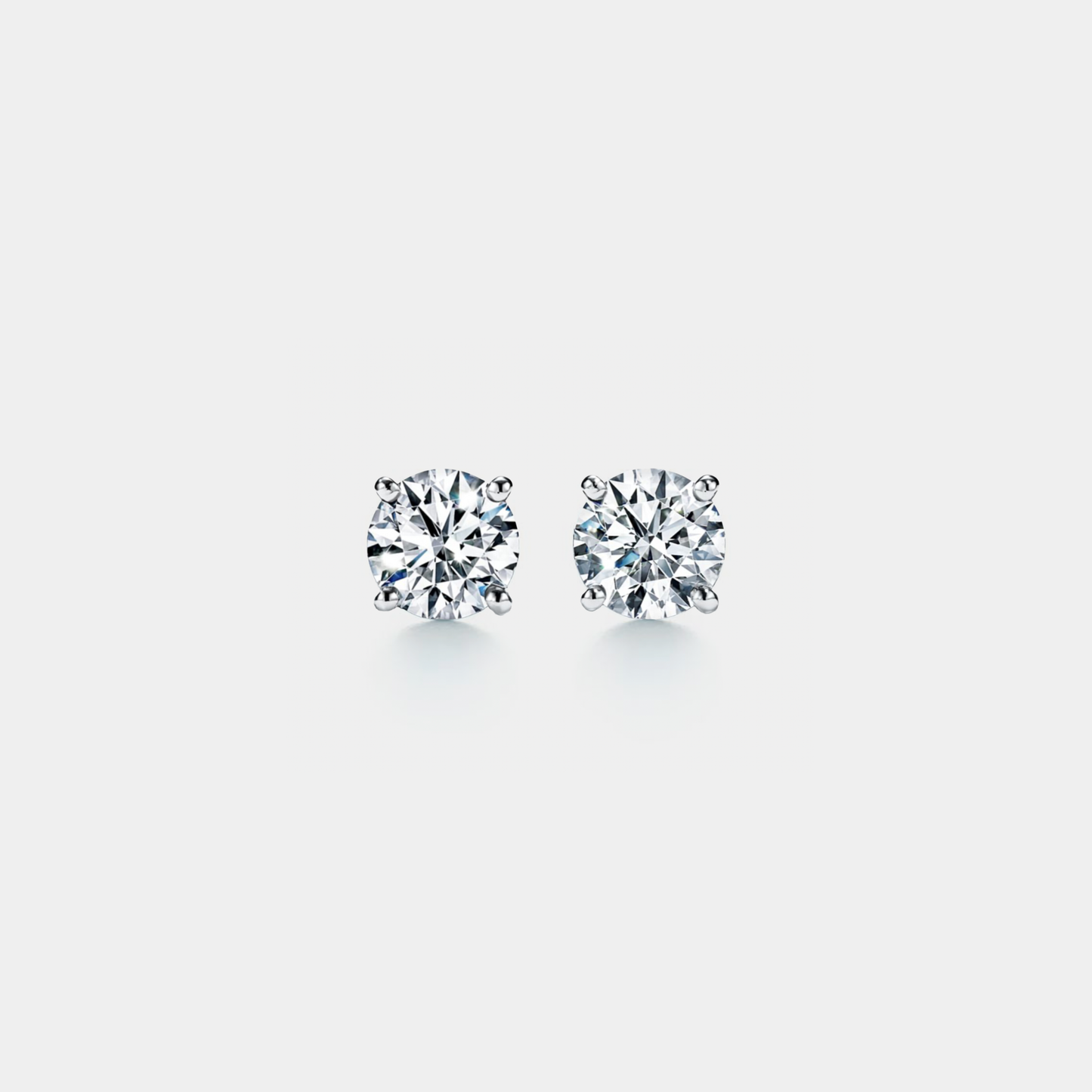 Pair of moissanite stud earrings on a light gray background