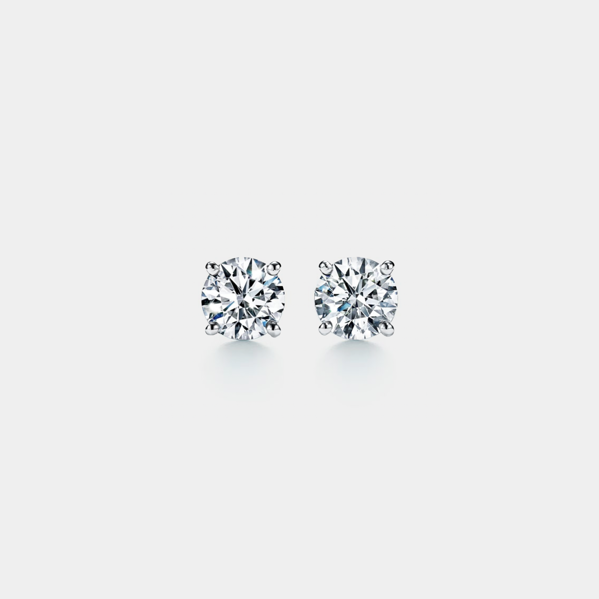 Pair of moissanite stud earrings on a light gray background