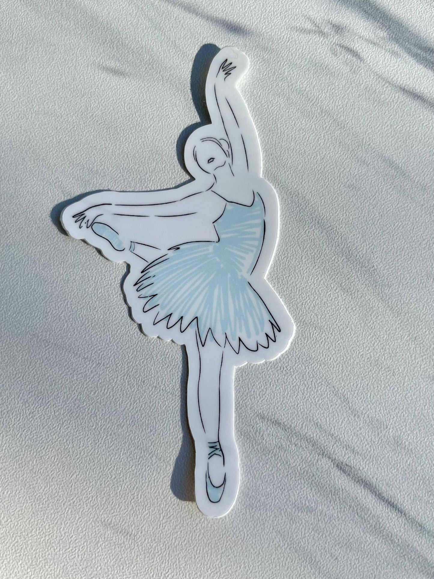 Sticker of a ballerina in a blue tutu on a light gray background