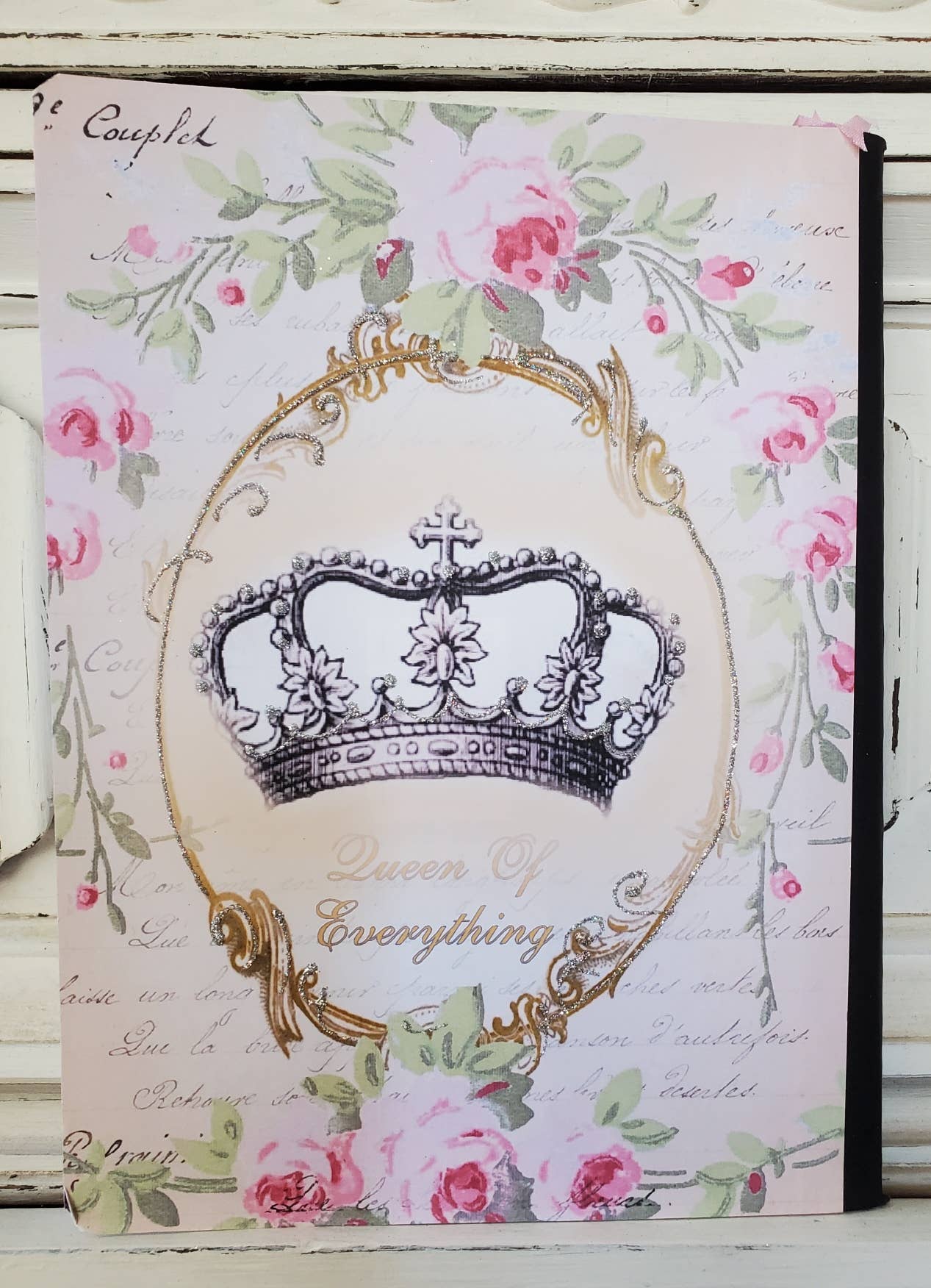 Decorative notebook with floral design and crown illustration on a white background
