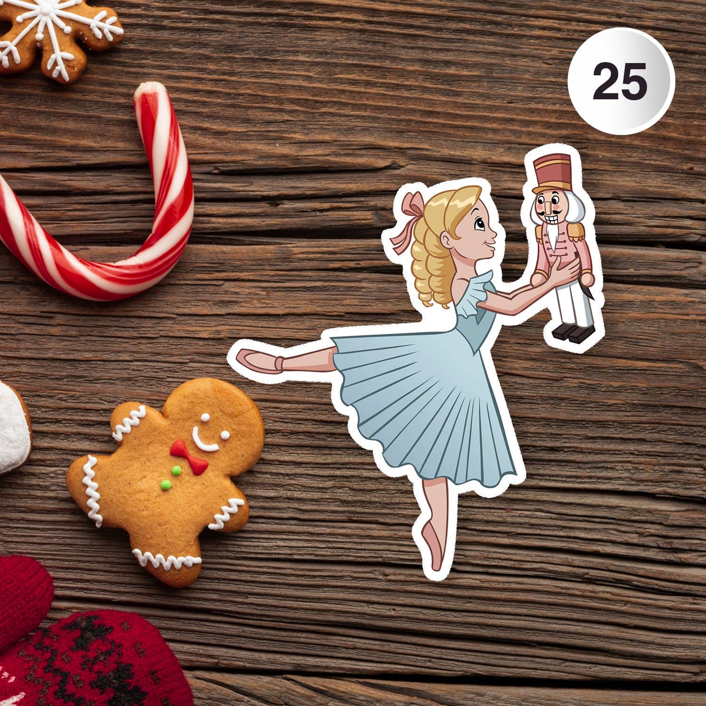 Sticker of a ballerina holding a nutcracker with Christmas cookies on a wooden surface.