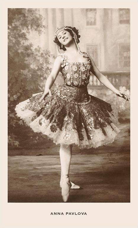 Vintage photograph of a ballerina in an ornate costume with a blurred background