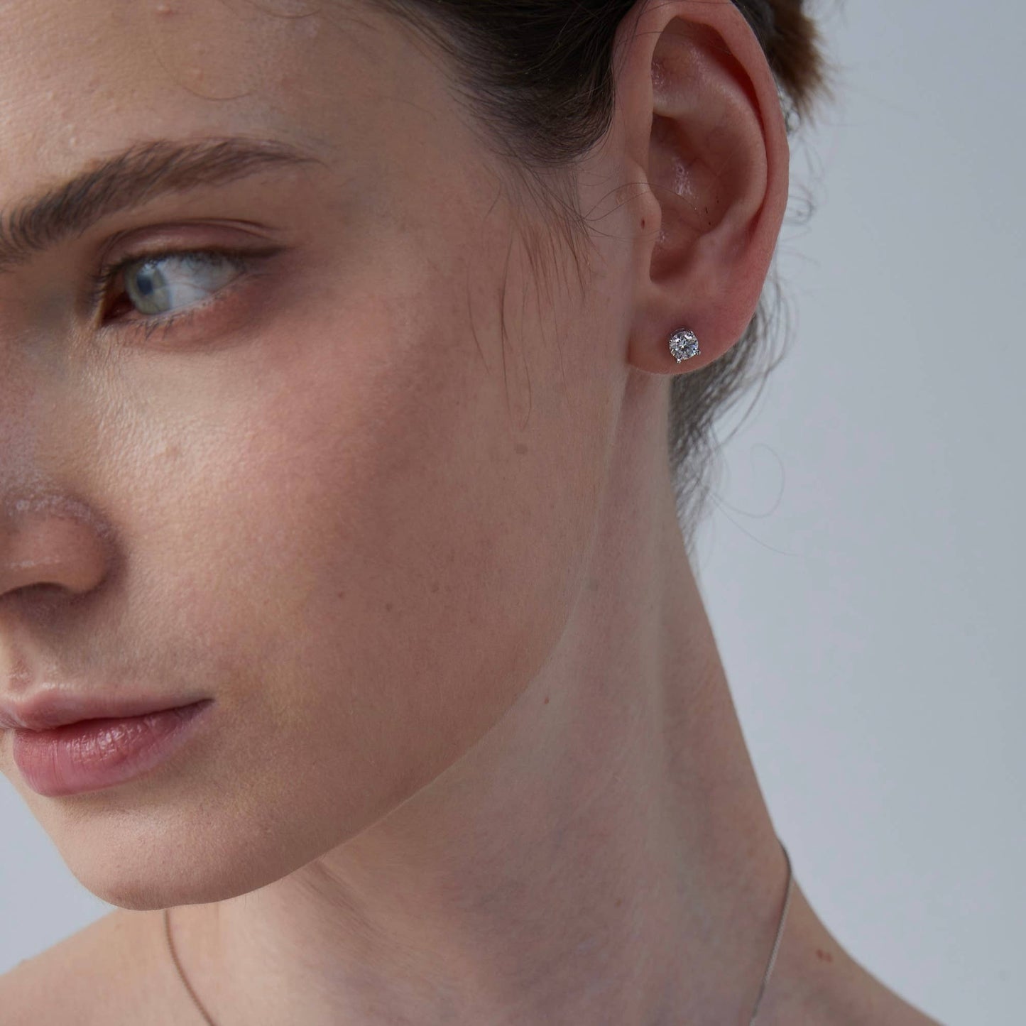 Close-up of a woman's face with a focus on her ear and earring.