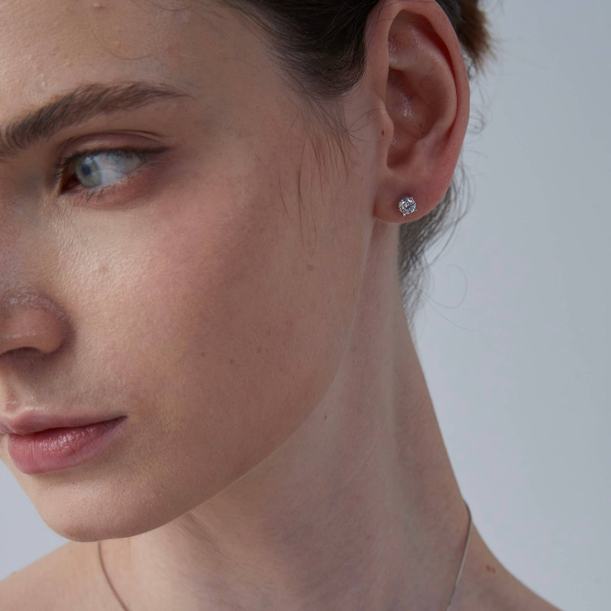 Close-up of a woman's face with a focus on her ear and earring.