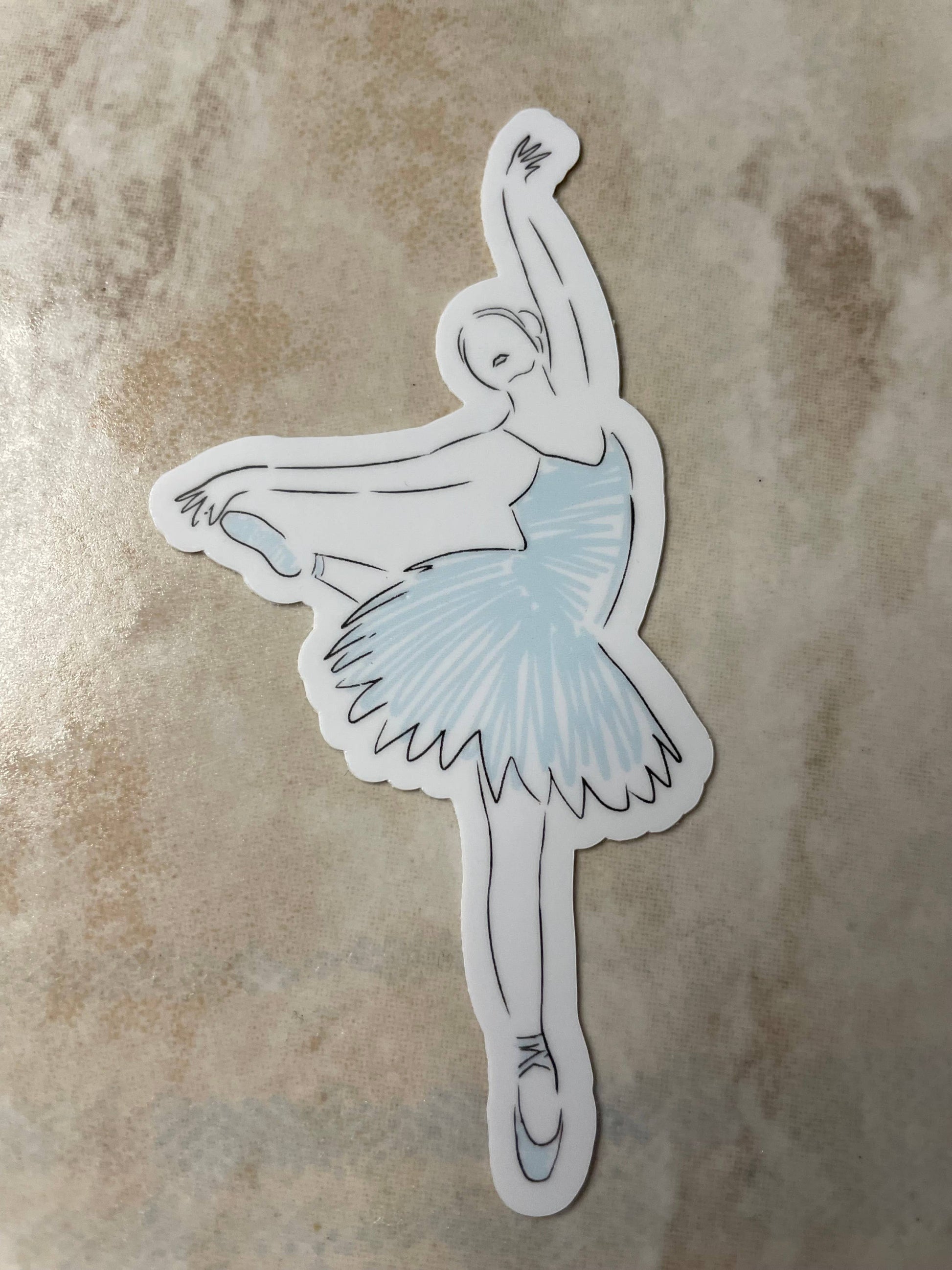 Sticker of a ballerina with a blue tutu on a textured beige background