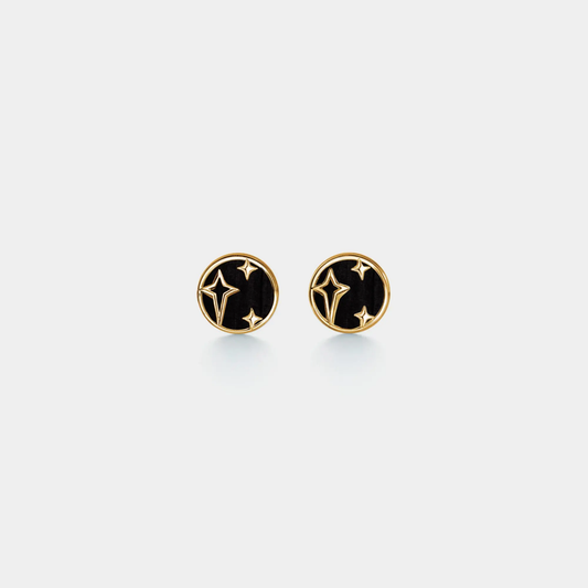 Pair of gold and black earrings on a light gray background